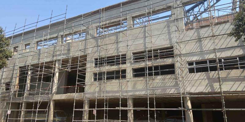Steel scaffolding erected against a multi-storey building under construction